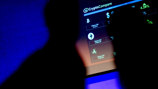 The symbols of Bitcoin and Ethereum cryptocurrencies sit displayed on a screen during the Crypto Investor Show in London. 