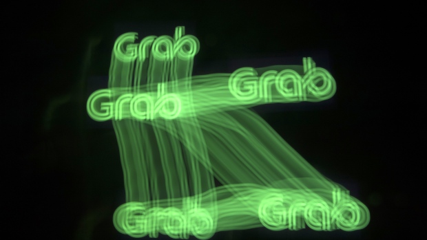 The Grab logo is see in this arranged long exposure photograph taken in Bangkok, Thailand, on Friday, March 9, 2018. Grab, the dominant ride-hailing service in Southeast Asia, is close to finalizing a deal to acquire Uber's business in the region and may sign a deal this week or next, according to people familiar with the matter. 