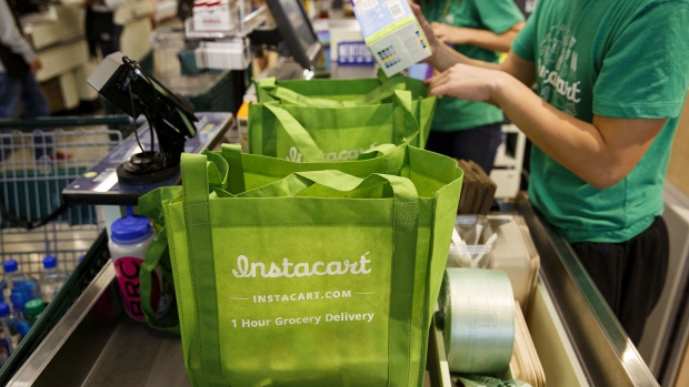 InstaCart employees fulfill orders for delivery at the new Whole Foods Market Inc. store in downtown Los Angeles, California, U.S., on Monday, Nov. 9, 2015. Located beneath the recently opened Eighth & Grand residences, the 41,000-square-foot store features a juice bar, fresh poke, expanded vegan options in all departments, a coffee bar (with cold brew on tap), more than 1,000 hand-picked wines, home delivery via Instacart and bar-restaurant The Eight Bar. 