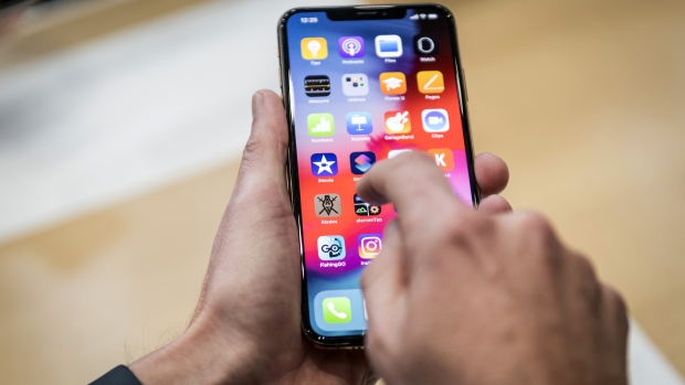An attendee demonstrates the Apple Inc. iPhone XR smartphone during an event at the Steve Jobs Theater in Cupertino, California, U.S., on Wednesday, Sept. 12, 2018. Apple Inc. took the wraps off a renewed iPhone strategy on Wednesday, debuting a trio of phones that aim to spread the company's latest technology to a broader audience. 