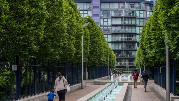 Pedestrians walk past fountains in view of residential development in the Nine Elms district of London, U.K., on Wednesday, May 23, 2018. Traditional lenders are charging more for loans or declining to offer money at all after a boom in prime properties ended and left builders with a record number of homes without buyers. 