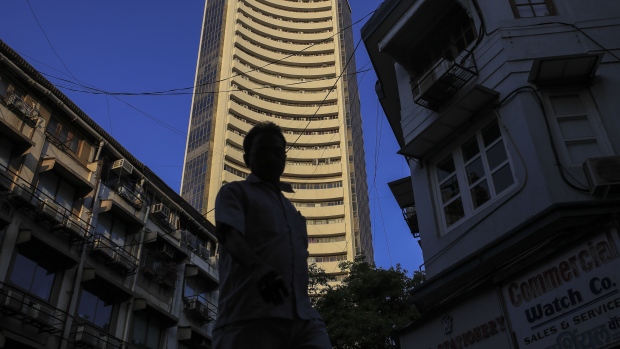 A pedestrian is silhouetted as the Bombay Stock Exchange (BSE) building, center, stands the background in Mumbai, India, on Tuesday, Dec. 11, 2018. India’s new central bank governor has a list of challenges to face as he takes office: from fixing a banking crisis to convincing investors of the institution’s autonomy. 