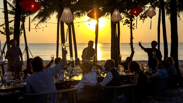 Chefs who had been invited by Red Boat to sample the sauce sit for a beachside feast. Photographer: Maika Elan/Bloomberg