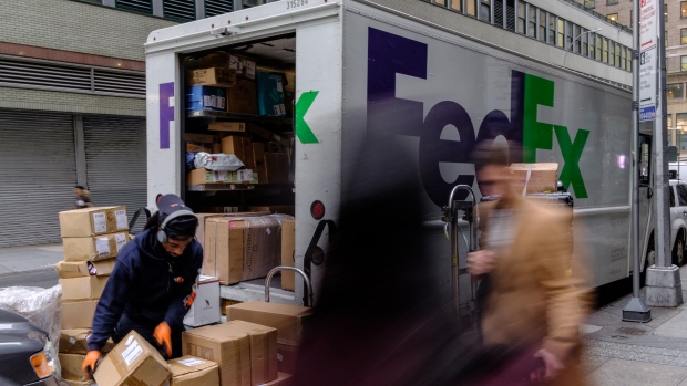 A driver for an independent contractor to FedEx Corp. unloads packages from a delivery truck in NY