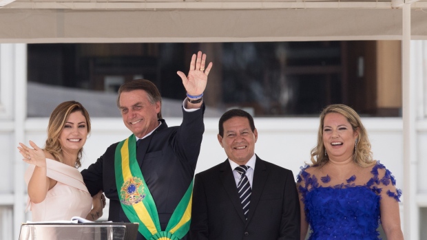Michelle Bolsonaro, Brazil's first lady, from left, and Jair Bolsonaro, Brazil's president, wave while Hamilton Mourao, Brazil's vice president, and his wife Paula Mourao, Brazil's second lady, stand during the 38th presidential inauguration at Planalto Palace in Brasilia, Brazil, on Tuesday, Jan. 1, 2019. Former Army captain Jair Bolsonaro is being sworn in as Brazil's president on Tuesday with the promise to tackle rampant crime, corruption and economic malaise in a wave of nationalism that's sweeping Latin America's largest country. Photographer: Patricia Monteiro/Bloomberg