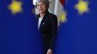 Britain’s Prime Minister Theresa May is seen behind EU flags as she arrives at the European Council.