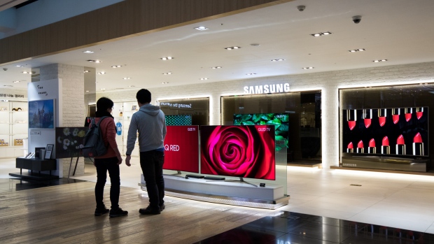 Customers look at Samsung Electronics Co. QLED televisions at the company's D'light flagship store in Seoul, South Korea, on Thursday, April 5, 2018. Samsung reported higher-than-projected profit as demand for its memory chips remained strong enough to outweigh concerns about display supplies to Apple Inc. 