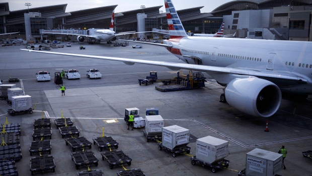 Cargo containers are transported to an American Airlines Group Inc. plane at Los Angeles International Airport (LAX) in Los Angeles. 