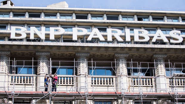 Construction workers stand on scaffolding outside a BNP Paribas SA headquarters in Paris, France, on Tuesday, July 18, 2017. BNP Paribas agreed to pay $246 million to settle Federal Reserve allegations that the bank failed to keep its currency traders from using electronic chatrooms to manipulate prices. 