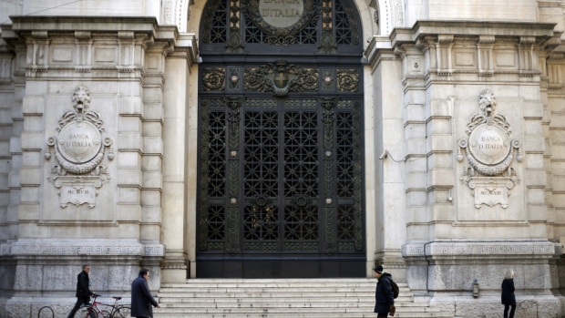 Pedestrians walk past the gated entrance to a regional branch of the Banca d'Italia, Italy's central bank, in Milan, Italy. 