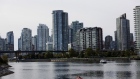 The city skyline stands as a woman kayaks at False Creek in downtown Vancouver, British Columbia, Canada, on Thursday, Oct. 3, 2013. 