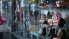 The reflection of a shopper is seen on a window as shoes are displayed for sale on Steinway Street in the Queens borough of New York, U.S.