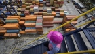 A worker walk down stairs as shipping containers sit stacked at the Port of Veracruz in Veracruz, Mexico. 