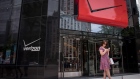 A pedestrian uses a smartphone outside a Verizon Communications Inc. store in downtown Chicago, Illinois, U.S.