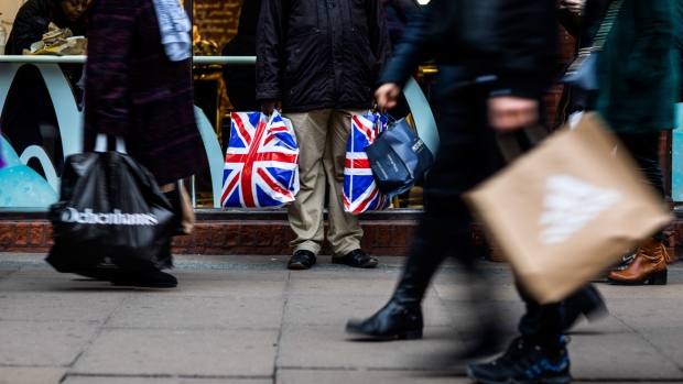 A pedestrian holds shopping bags branded with the Union Flag, also know as Union Jack, on Oxford Street in central London, U.K., on Tuesday, Dec. 4, 2018. U.K. consumer spending growth slowed in November as concerns about Brexit prompted households to become more cautious with their cash. 