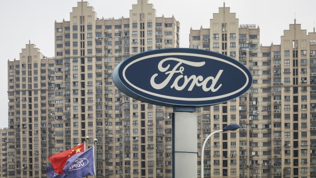 A Ford Motor Co. sign stands next to a Chinese national flag, second left, and Ford cooperate flags in Shanghai, China, on Sunday, July 8, 2018. The long threatened trade war escalated just after midnight in Washington on July 6 when the U.S. imposed tariffs on $34 billion of Chinese imports and Beijing immediately said it would be forced to retaliate. 