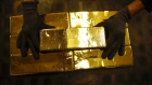 A worker stacks 12.5 kilogram gold bullion bars at the Valcambi SA precious metal refinery in Balerna, Switzerland. 