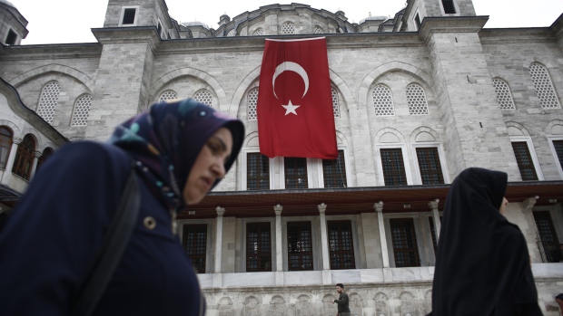 Pedestrians pass a Turkish flag hanging from the Fatih Mosque ahead of a demonstration against the relocation of the U.S. embassy to Jerusalem in Istanbul, Turkey, on Friday, May 11, 2018. No major power recognized Israeli sovereignty in Jerusalem until U.S. President Donald Trump did so on Dec. 6. 
