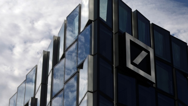 The Deutsche Bank AG logo sits on an office building in Frankfurt, Germany, on Wednesday, April 25, 2018. Germany’s largest lender will scale back U.S. rates sales and trading, reduce the corporate finance business in the U.S. and Asia, and review its global equities business with a view toward cutting it back, the bank said in a statement Thursday. 