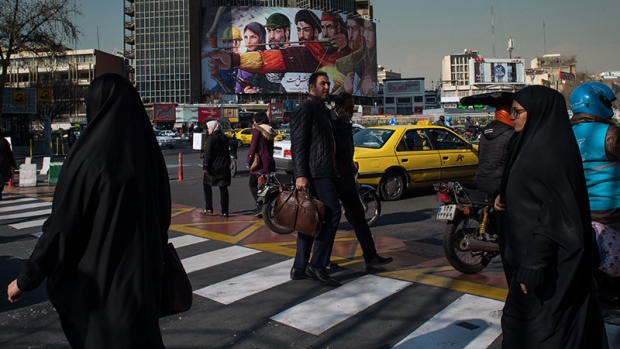 Women wearing chadors walk across a busy pedestrian crossing in Tehran, Iran, on Monday, Jan. 8, 2018. A wave of bad loans from unregulated lenders has rocked the banking sector and oil prices have averaged less than $60 a barrel for the past three years, draining Iran of a key source of revenue. 