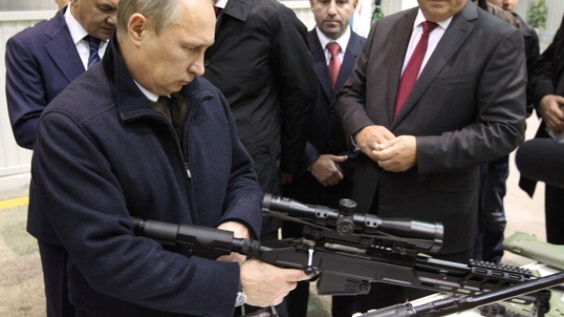 IZHEVSK, RUSSIA - SEPTEMBER 18: Russian President Vladimir Putin (L) holds a Kalashnikov machine gun during his visit to the Kalashnikov manufacturing plant September 18, 2013 in Izhevsk, Russia. The plant, which manufactures the Kalashnikov assault rifle, is one of the largest in its field. (Photo by Sasha Mordovets/Getty Images)