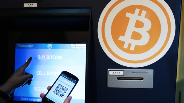 Eugene Aono, a spokesperson for BMEX bitcoin exchange, demonstrates usage of the company's Robocoin-branded automated teller machine (ATM) at The Pink Cow restaurant and bar in Tokyo, Japan, on Wednesday, June 18, 2014.