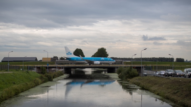 A passenger aircraft operated by KLM, the Dutch arm of Air France-KLM Group, crosses a bridge after landing at Schiphol airport in Amsterdam, Netherlands, on Tuesday, Aug. 15, 2017. Delta Air Lines Inc., China Eastern Airlines Corp. and Air France-KLM Group are reaching for their checkbooks to forge a deeper global alliance. 