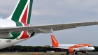 An EasyJet airplane rolls on the tarmac past an Alitalia plane on June 21, 2018 at the Fiumicino Airport, in Rome. 