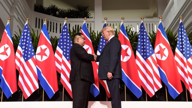 North Korea's leader Kim Jong Un (L) shakes hands with US President Donald Trump (R) at the start of their historic US-North Korea summit, at the Capella Hotel on Sentosa island in Singapore on June 12, 2018.