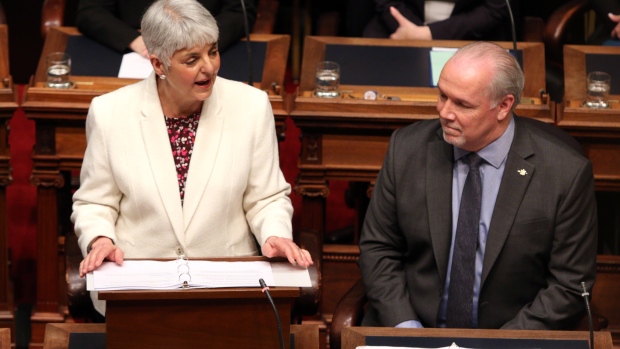 Premier John Horgan looks on as Finance Minister Carole James delivers the budget speech