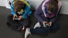 RUESSELSHEIM, GERMANY - SEPTEMBER 22: Children play video games on smartphones while attending a public event on September 22, 2012 in Ruesselsheim, Germany. Smartphones, with their access to social networks, high-resolution screens, video games and internet acess, have become commonplace among children and teenagers across the globe. (Photo by Sean Gallup/Getty Images)