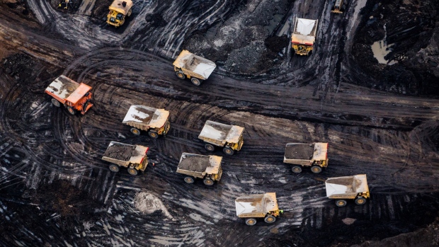 Heavy haulers are seen at the Suncor Energy Inc. Fort Hills mine in this aerial photograph taken above the Athabasca oil sands near Fort McMurray, Alberta, Canada, on Monday, Sept. 10, 2018. While the upfront spending on a mine tends to be costlier than developing more common oil-sands wells, their decades-long lifespans can make them lucrative in the future for companies willing to wait. 