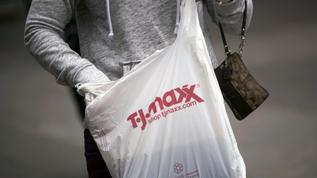 A shopper carries a bag outside a TJ Maxx store in New York, U.S., on Friday, May 18, 2018.  
