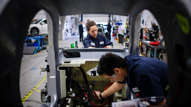 Workers assemble an Electra Meccanica Vehicles Corp. Solo electric car at the company's production facility in New Westminster, British Columbia, Canada, on Thursday, Dec. 20, 2018. Electra Meccanica, which has a market value of just $41 million, yet $2.4 billion in pre-orders, says its quirky reimagination of an automobile aims to redefine the category. 