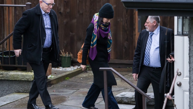 Meng Wanzhou, chief financial officer of Huawei Technologies Co., center, leaves her home under the supervision of security in Vancouver, British Columbia, Canada, on Wednesday, Dec. 12, 2018. President Donald Trump is talking about wading into the legal fight of the Huawei CFO, saying in an interview that he would intervene in U.S. efforts to extradite Meng if it helped him win a trade deal with China. 