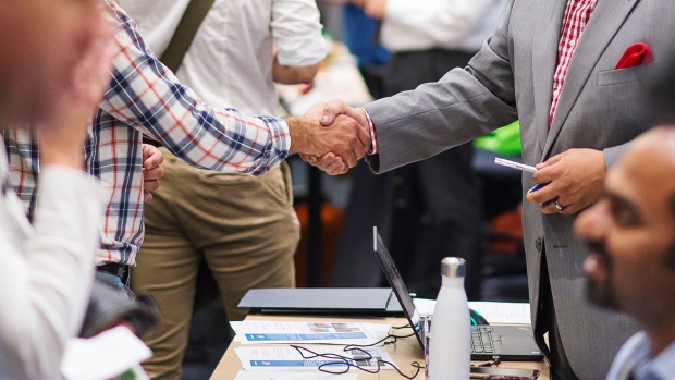 A job seeker shakes hands with a representative during the Vancouver Job Fair, presented by Work BC and operated by YWCA Metro Vancouver, in Vancouver, British Columbia, Canada, on Wednesday, Sept. 26, 2018. 