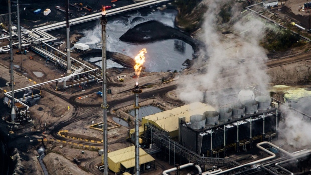 Flames shoot from a flare at the Suncor Energy Inc. Millennium upgrader plant in this aerial photograph taken above the Athabasca oil sands near Fort McMurray, Alberta, Canada. 