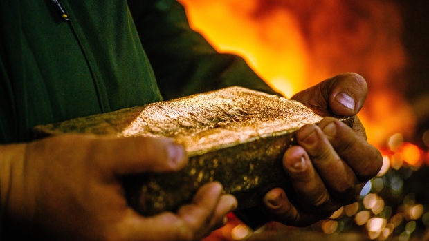 A worker carries a 28 kilogram gold bar after casting and cleaning in the foundry at the South Deep gold mine, operated by Gold Fields Ltd., in Westonaria, South Africa. 