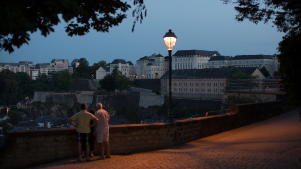 Sightseers stand on the city's old fortifications at dusk in Luxembourg, on Wednesday, June 14, 2017. 