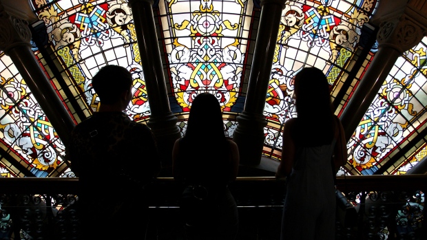 Shoppers are silhouetted as they stand against stained glass windows inside the Queen Victoria Building shopping arcade in Sydney, Australia, on Friday, Jan. 11, 2019. Australian consumer confidence slumped the most in more than three years, amid pessimism over falling property prices and economic growth, after the nation's dollar tumbled to the weakest in almost 10 years at the beginning of the month. 