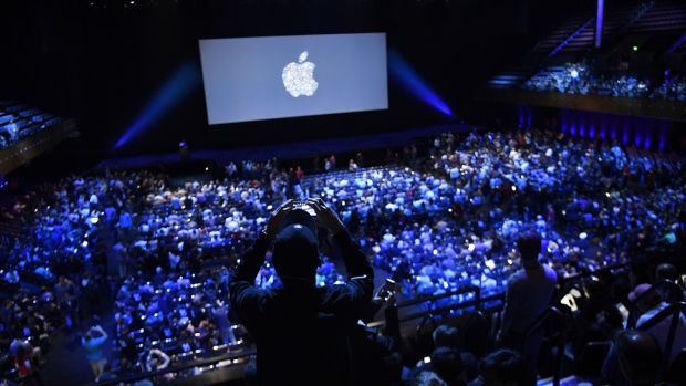 An attendee uses a mobile device to take photograph before the start of the Apple World Wide Developers Conference (WWDC) in San Francisco, California, U.S., on Monday, June 13, 2016. 