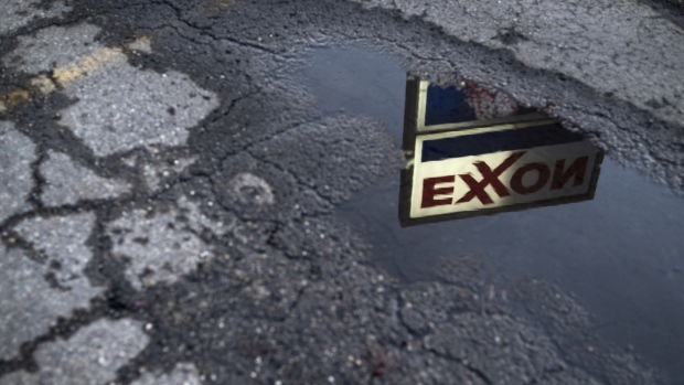 Exxon Mobil Corp. signage is reflected in a puddle at a gas station in Nashport, Ohio, U.S., on Friday, Jan. 26, 2018. 