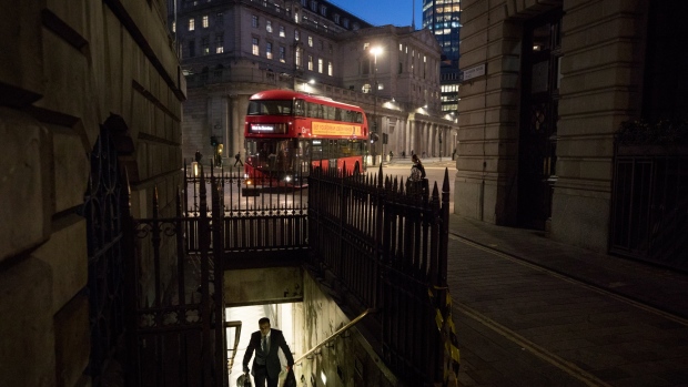 A commuter exits an entrance to Bank Underground station in view of the Bank of England in the City of London. 