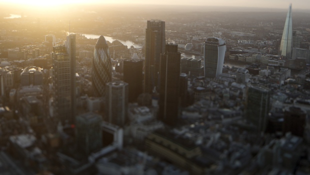 The early morning sun rises beyond skyscrapers including Tower 42, the Heron Tower, the Leadenhall building, also known as the "Cheesegrater," 30 St Mary Axe, also known as "the Gherkin," 20 Fenchurch Street, also known as the "Walkie-Talkie," and the Shard stand surrounded by commercial office buildings in this aerial photograph taken with a tilt-shift lens over the City of London, U.K. 