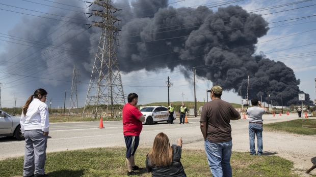 Residents look on at the plume of smoke rising from a fire at the Intercontinental Terminals petrochemical storage site in Deer Park, Texas on March 19, 2019. Photographer: Scott Dalton/Bloomberg