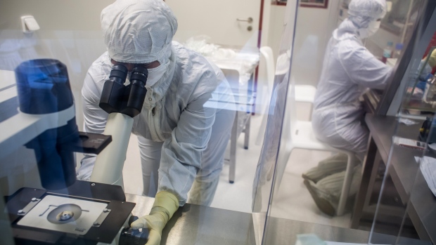 A laboratory specialist uses a microscope to check cells during the last phase of vaccine manufacture inside a clean laboratory at the Sotio AS biotechnology company in Prague, Czech Republic. 