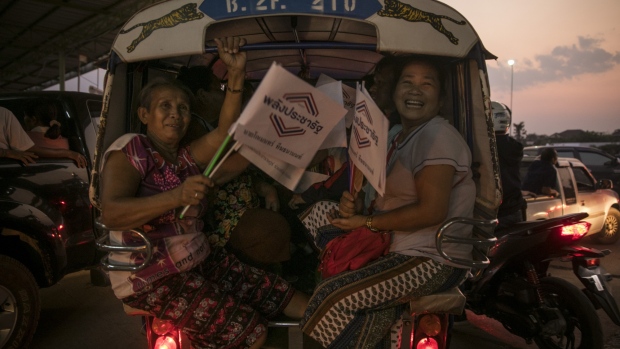 People carrying Palang Pracharath party flags leave a rally in Udon Thani, Thailand, on Friday, March 8, 2019. Thaksin Shinawatra hasn’t set foot in Thailand since he was convicted in a corruption case brought after a 2006 coup that deposed him. But in the poor northeast the billionaire former prime minister’s allies have won won every election since 2001. The March 24 election will again test whether Thailand’s rural masses repudiate its coup-prone generals, who’ve ruled the country since seizing power in 2014. Photographer: Brent Lewin/Bloomberg