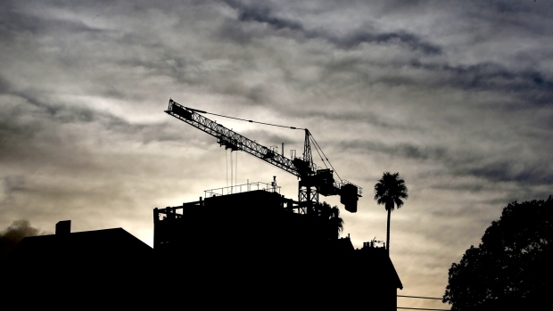 A crane is silhouetted as it operates at a residential construction site in the suburb of North Sydney in Sydney, Australia, on Wednesday, June 20, 2018. Australia is riding out a huge gamble on property. The bet: 27 years of recession-free economic growth—during which Sydney home prices surged fivefold—would continue unabated and allow borrowers to keep servicing their debt. 