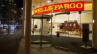 Pedestrians pass in front of a Wells Fargo & Co. bank branch at night in New York. 