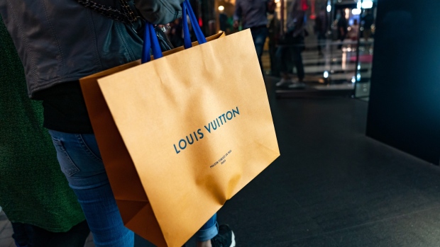 A shopper carries a LVMH Moet Hennessy Louis Vuitton SE branded shopping bag on Canton Road in the Tsim Sha Tsui district of Hong Kong, China, on Sunday, Feb. 3, 2019. The week-long Lunar New Year holiday, starting Feb. 4, will provide the next litmus test of the resilience of the Chinese shopper. The seven-day period sees hundreds of millions of people travel within the country to see relatives, fly overseas to takevacations - and open their wallets to buy gifts. Photographer: Anthony Kwan/Bloomberg